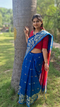 Handwoven blue Shantipuri Tant saree with woven motifs and contrasting red pallu from West Bengal, shown in full drape.