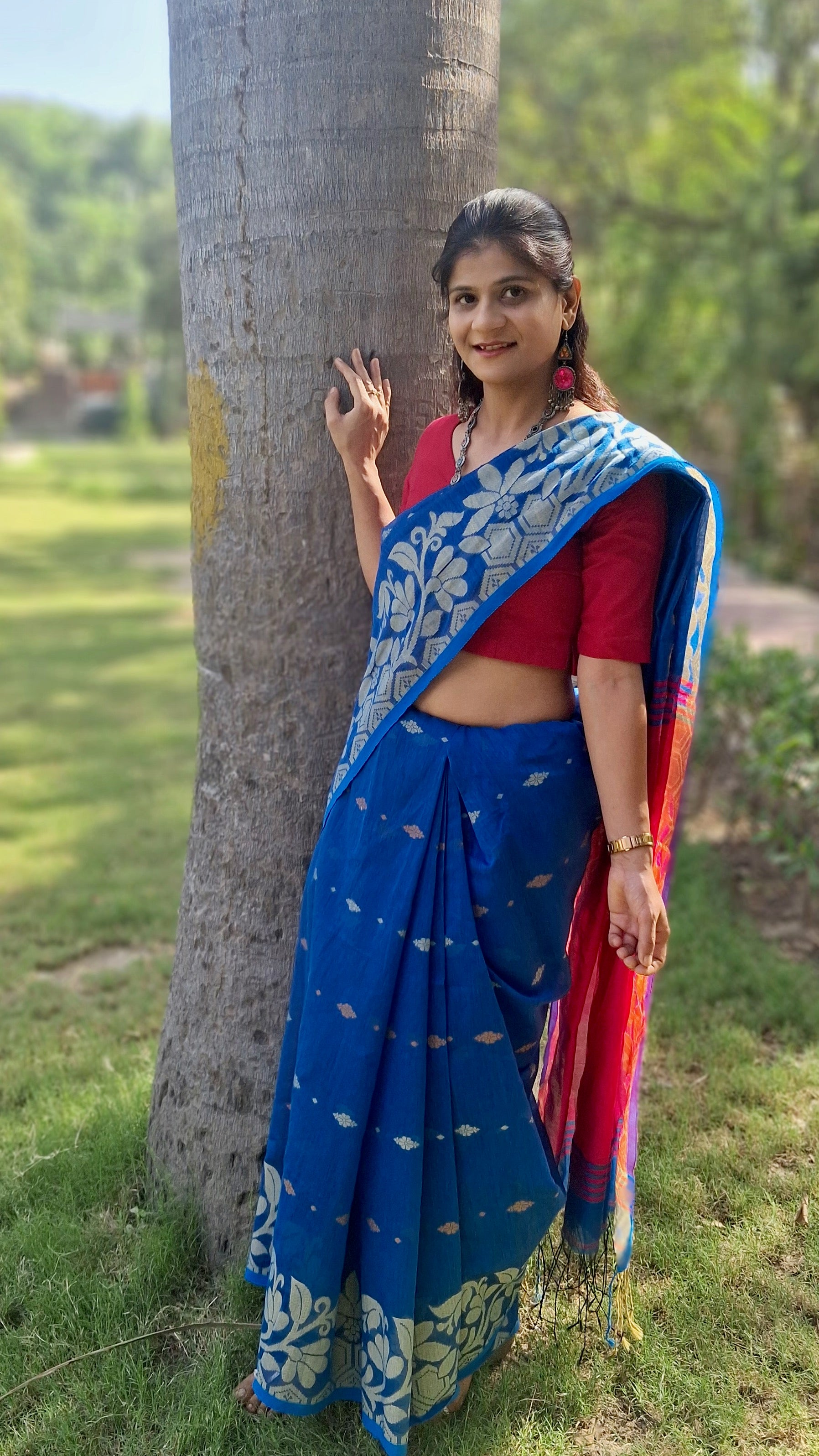 Handwoven blue Shantipuri Tant saree with woven motifs and contrasting red pallu from West Bengal, shown in full drape.