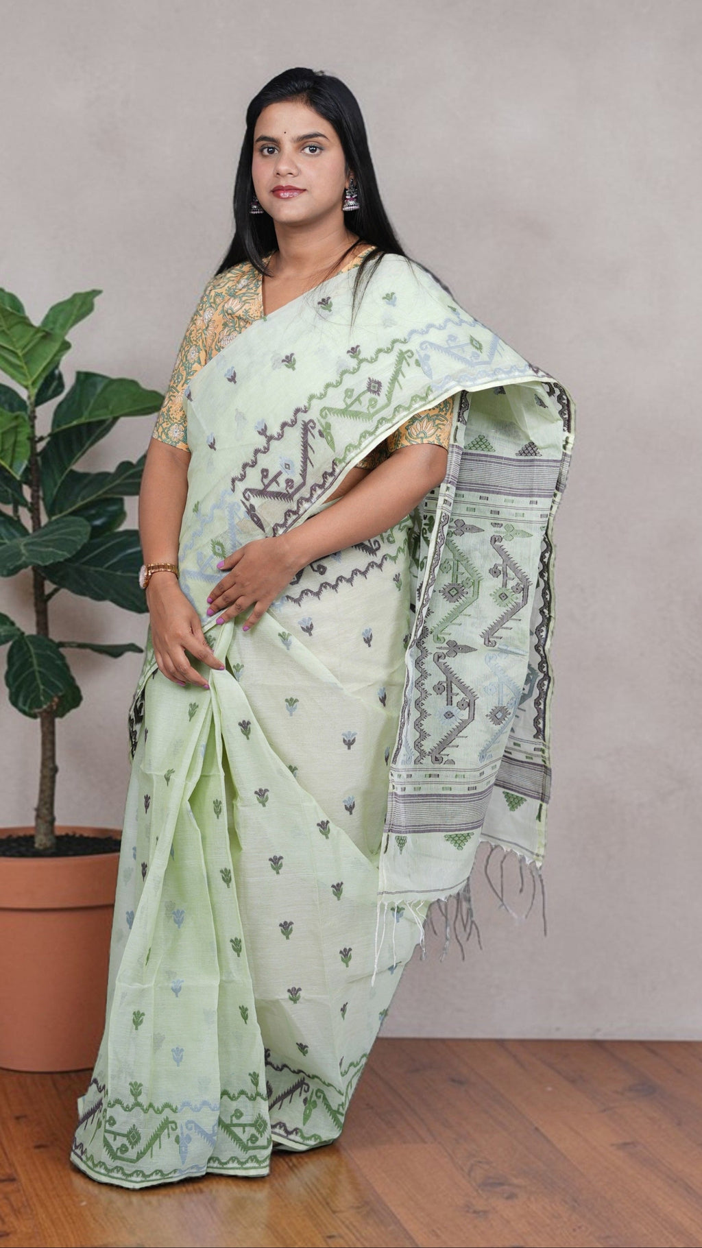 right view of model draped in a mint green Baluchari Taant cotton saree with jacquard-woven motifs from West Bengal.