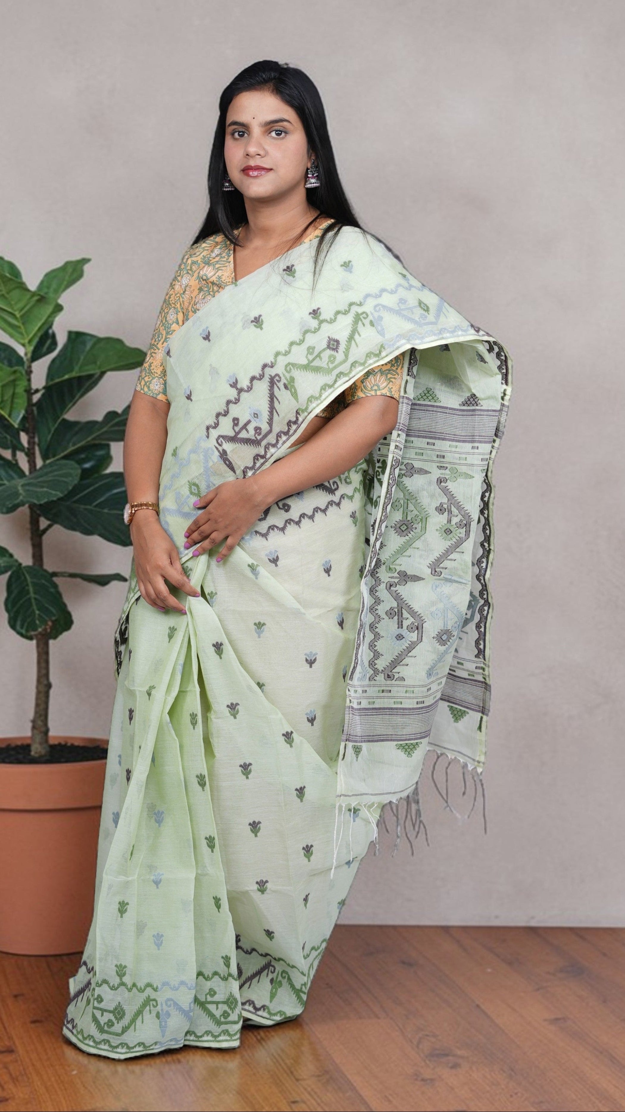 right view of model draped in a mint green Baluchari Taant cotton saree with jacquard-woven motifs from West Bengal.
