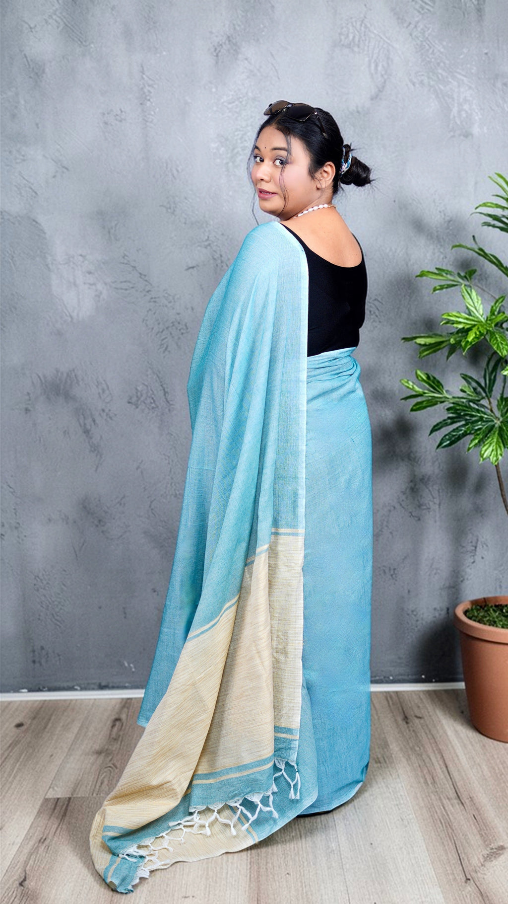 pallu close up view of model wearing soft aqua blue khadi cotton handloom saree with natural beige border woven in West Bengal.