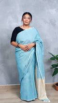 Model wearing soft aqua blue khadi cotton handloom saree with natural beige border woven in West Bengal